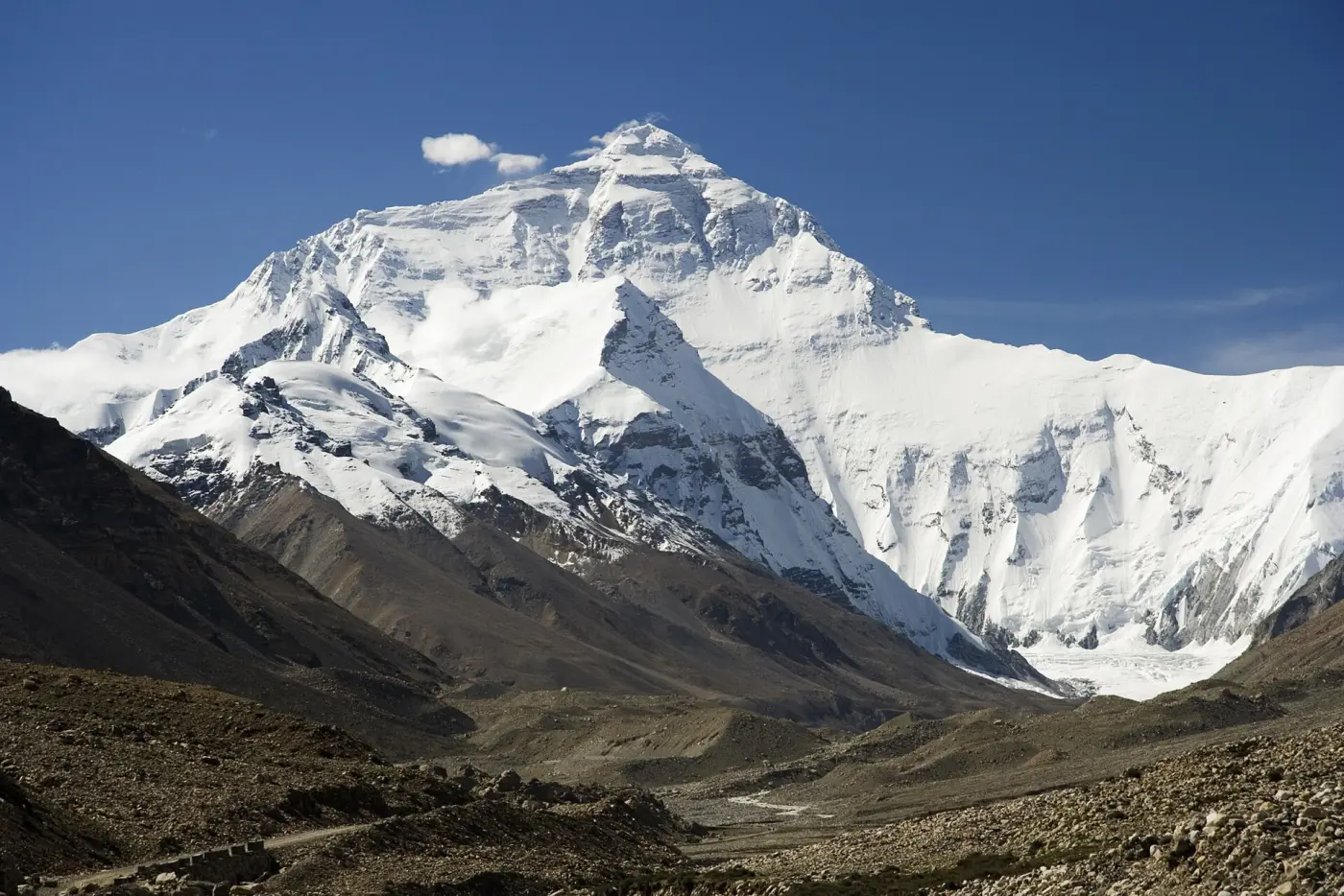 The snow-covered north face of Mount Everest against a blue sky