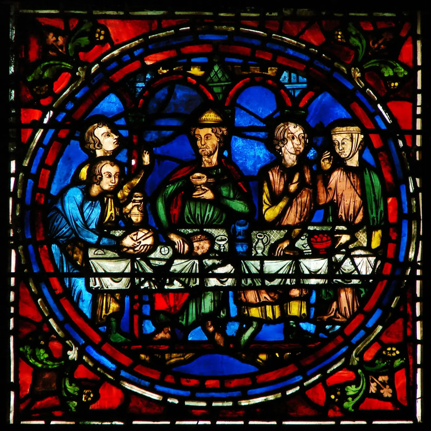 Medieval stained-glass window of Chartres Cathedral showing a table scene
