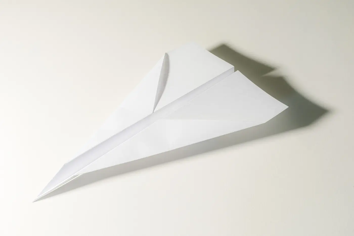 A paper plane made of white paper on a light background