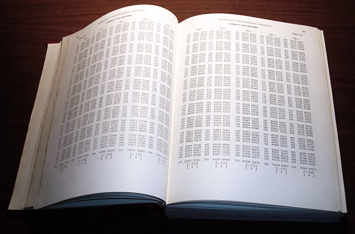 An open book of tables with densely printed columns of logarithms