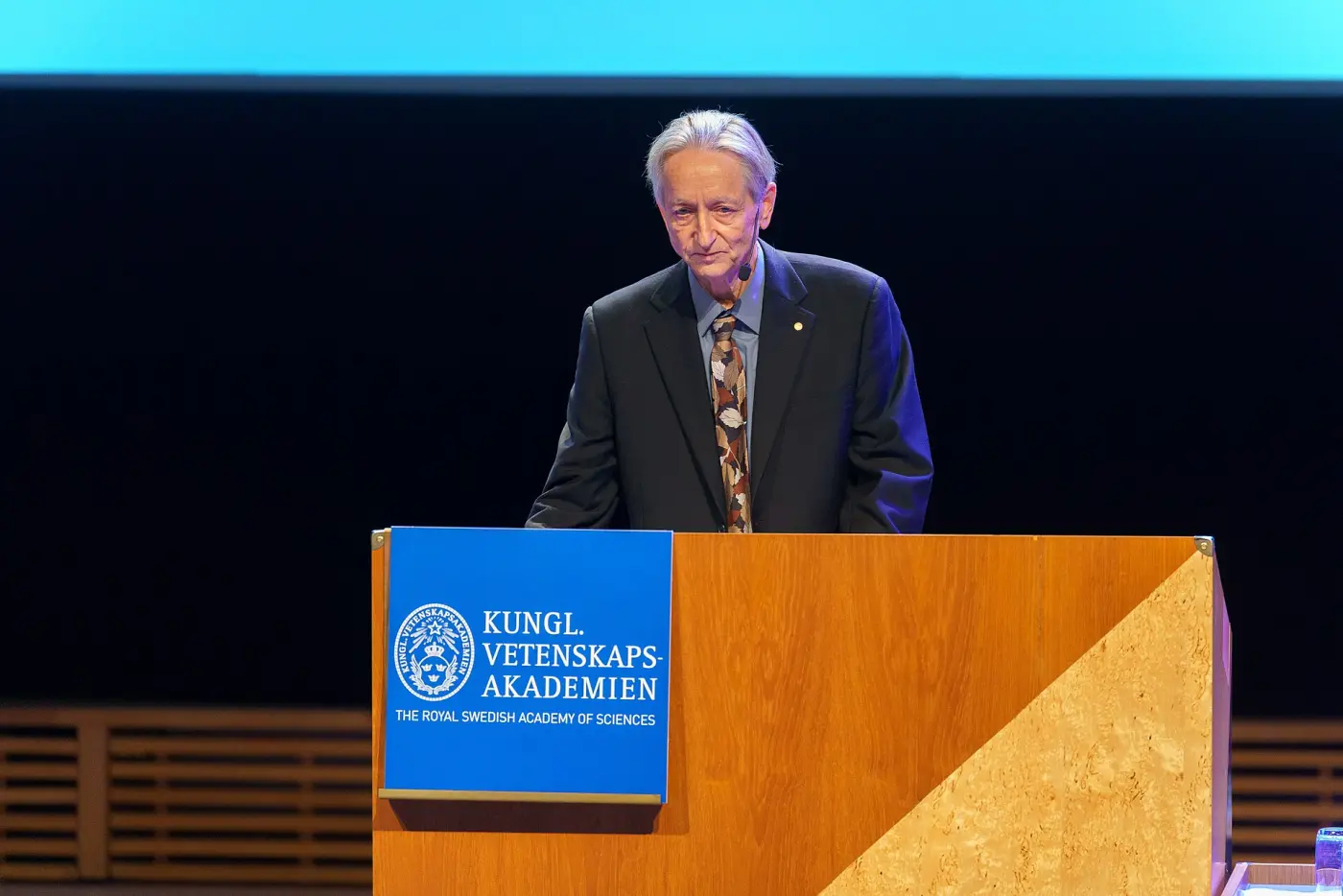 Geoffrey Hinton speaking at a lectern of the Royal Swedish Academy of Sciences