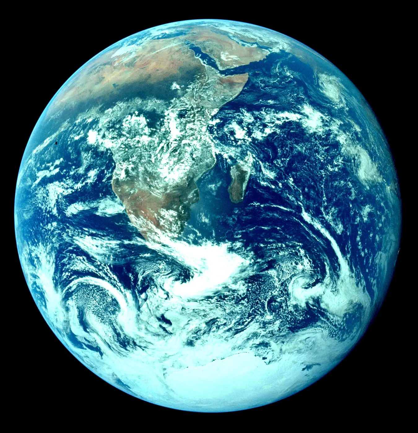 Die ganze Erde als blaue Kugel im All, mit Afrika, Arabien und der Antarktis unter Wolkenwirbeln